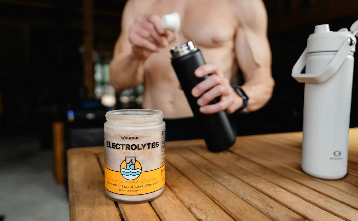A man scoops Coconut Nectar Electrolytes into a black bottle at a table